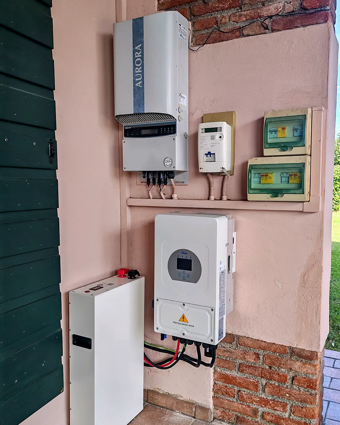 Inversor Aurora existente con inversor híbrido Deye y batería instalados bajo un porche